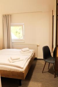 ein Schlafzimmer mit einem Bett, einem Stuhl und einem Fenster in der Unterkunft Golden Golem hotel & Spa in Prag