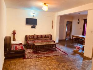 a living room with a couch and a table at Ganga Cottage !! 1,2,3 bedrooms cottage available near mall road manali in Manāli