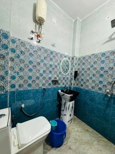 La salle de bains est pourvue de toilettes et de carrelage bleu et blanc. dans l'établissement Hotel Sapphire Grand - Onyx Plaza, à Ghaziabad