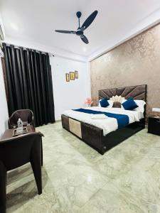 a bedroom with a bed and a table and a ceiling fan at Hotel Sapphire Grand - Onyx Plaza in Ghaziabad