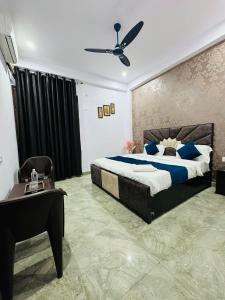 a bedroom with a bed and a table and a ceiling fan at Hotel Sapphire Grand - Onyx Plaza in Ghaziabad