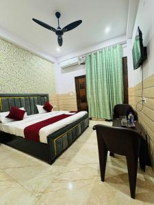 a bedroom with a bed and a chair and a table at Hotel Sapphire Grand - Onyx Plaza in Ghaziabad