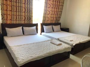 2 Einzelbetten in einem Schlafzimmer mit Fenster in der Unterkunft Nam Dương 2 Hotel in Phan Rang