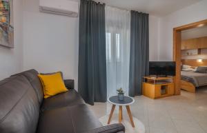 - un salon avec un canapé et une télévision dans l'établissement Apartments Kvarner 2, à Malinska