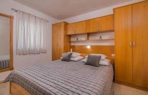 1 dormitorio con 1 cama grande y armarios de madera en Apartments Kvarner 2 en Malinska