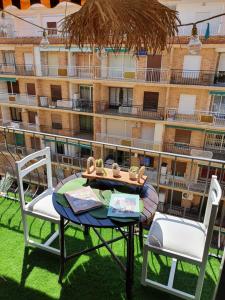 a table and chairs on a balcony with a building at apartamento playa surf cullera in Cullera
