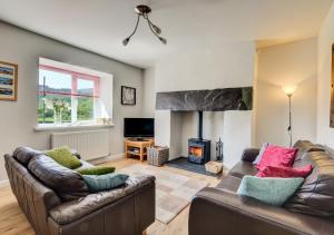 a living room with two couches and a fireplace at Carreg Cottage in Capel-Curig