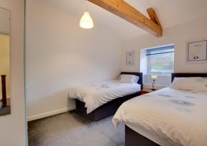 凱珀爾克里格的住宿－Carreg Cottage，一间卧室设有两张床和窗户。