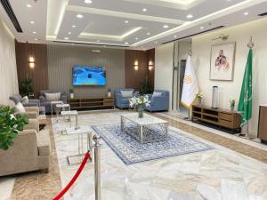 vestíbulo con sofás, sillas y TV en أوفاز للشقق المخدومة en Riad