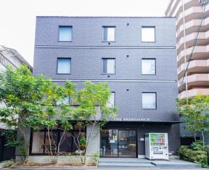 a brick building with a sign in front of it at JA Hotel Midoribashi 綠橋 in Osaka