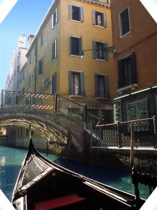 una góndola que pasa bajo un puente sobre un canal en Albergo San Marco en Venecia