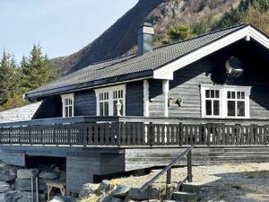 a wooden house with a porch and a mountain at 7 person holiday home in Selje-By Traum in Selje