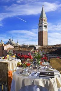 una mesa con manteles blancos y una torre de reloj en Albergo San Marco, en Venecia
