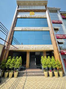 a building with potted plants in front of it at BLD Restaurant And Home Stay in Dehradun