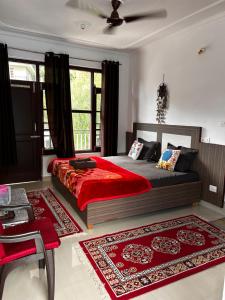 - une chambre dotée d'un grand lit avec des draps et des oreillers rouges dans l'établissement Nature's View Homestay, Travellers, à McLeod Ganj