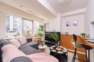 een woonkamer met een bank en een tafel bij CoCoHouse Asakusa - SkyTree View, 72㎡ in Tokyo
