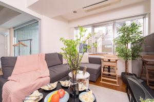 uma sala de estar com um sofá e uma mesa em CoCoHouse Asakusa - SkyTree View, 72㎡ em Tóquio