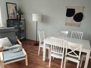 a dining room with a white table and chairs at Viscosa Holiday Apartment in Kõrgessaare