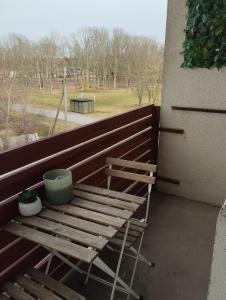 a wooden bench sitting on a balcony with a plant at Viscosa Holiday Apartment in Kõrgessaare