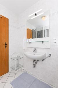 a bathroom with a sink and a mirror at Haus Strandlooper in Neuharlingersiel