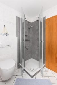 een badkamer met een douche en een toilet bij Haus Strandlooper in Neuharlingersiel