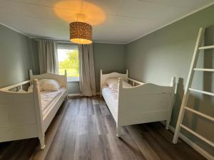 a bedroom with two beds and a window at Ferienwohnung Captains Lodge Steinbergkirche in Steinbergkirche