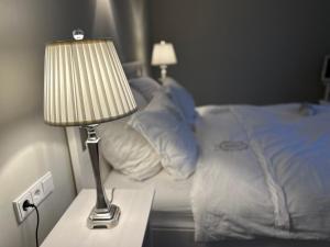 a lamp on a night stand next to a bed at Ferienwohnung Captains Lodge Steinbergkirche in Steinbergkirche