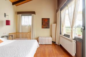 um quarto com uma cama branca e uma janela em Almarinae apartamentos em Castiello de la Marina