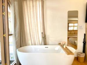 a white bath tub in a bathroom with a mirror at Tonsak Resort in Ko Samed