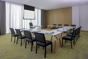 Staybridge Suites Dubai Business Bay, an IHG Hotel في دبي: قاعة المؤتمرات مع طاولة وكراسي طويلة