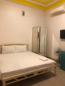 łóżko w pokoju z lodówką w obiekcie Nam Dương 3 Hotel w mieście Phan Rang-Tháp Chàm