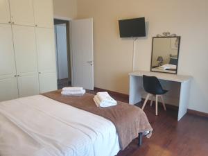 a bedroom with a bed and a desk and a chair at Great View City Appartment in Agios Rokkos