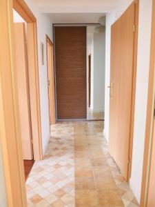 a hallway with a door and a tiled floor at Apartament Jelitkowski Dwór in Gdańsk