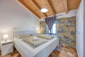 a bedroom with a bed and a stone wall at Istrian Casa Pr Marici in Pobegi