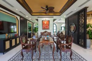 sala de estar con mesa y sillas en Stella Marina Boutique Hotel en Phu Quoc