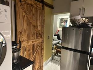 a kitchen with a refrigerator and a living room at Luxury one bedroom condo in Kitchener