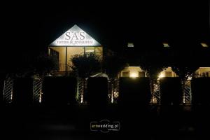 a building with a sas sign on it at night at SAS rooms & restaurant in Długie