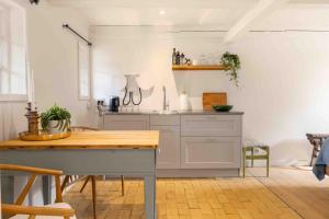 een keuken met een wastafel en een tafel in een kamer bij Solbjerggaard Studio Apartments in Fåborg