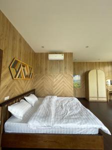 a bedroom with a large bed with white sheets at Sapa J&K Homestay and Swimming Pool in Sa Pa