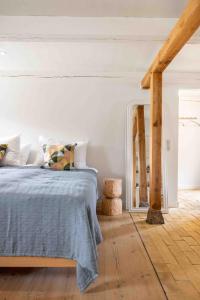 a white bedroom with a bed and a mirror at Solbjerggaard Studio Apartments in Faaborg