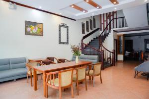 ein Esszimmer mit einem Tisch, Stühlen und einer Treppe in der Unterkunft lotus hotel 2 khách sạn bắc ninh in Bắc Ninh