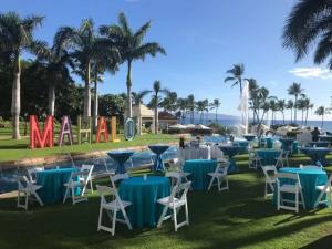 un groupe de tables et de chaises avec l'océan en arrière-plan dans l'établissement Grand Wailea Resort Hotel & Spa, A Waldorf Astoria Resort, à Wailea