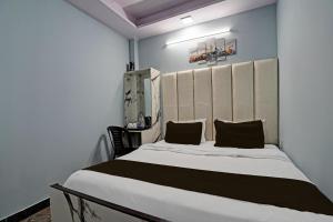 um quarto com uma grande cama branca e 2 almofadas em OYO Hotel Star em Nova Deli
