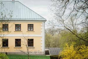 a white house with windows and a roof at Barona spilvens in Kazdanga