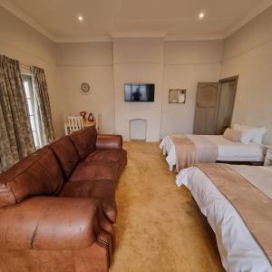 a living room with a couch and two beds at Journey Guesthouse in Riversdale