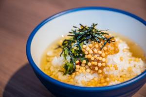 a bowl of food with corn and greens on top at Hiyori Hotel Maihama in Urayasu