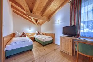 pokój z dwoma łóżkami i telewizorem w obiekcie Hotel Hofbrunn w mieście Riffian