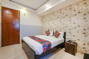 a bedroom with a bed and a wooden door at FabExpress 24 Plus in Bangalore