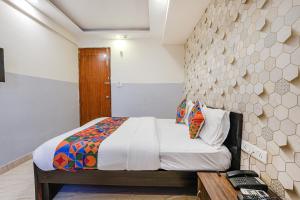 a bedroom with a bed and a desk with a telephone at FabExpress 24 Plus in Bangalore