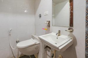a white bathroom with a sink and a toilet at FabExpress 24 Plus in Bangalore
